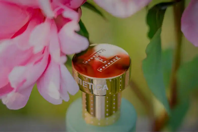 Gold-colored perfume bottle cap with decorative patterns.