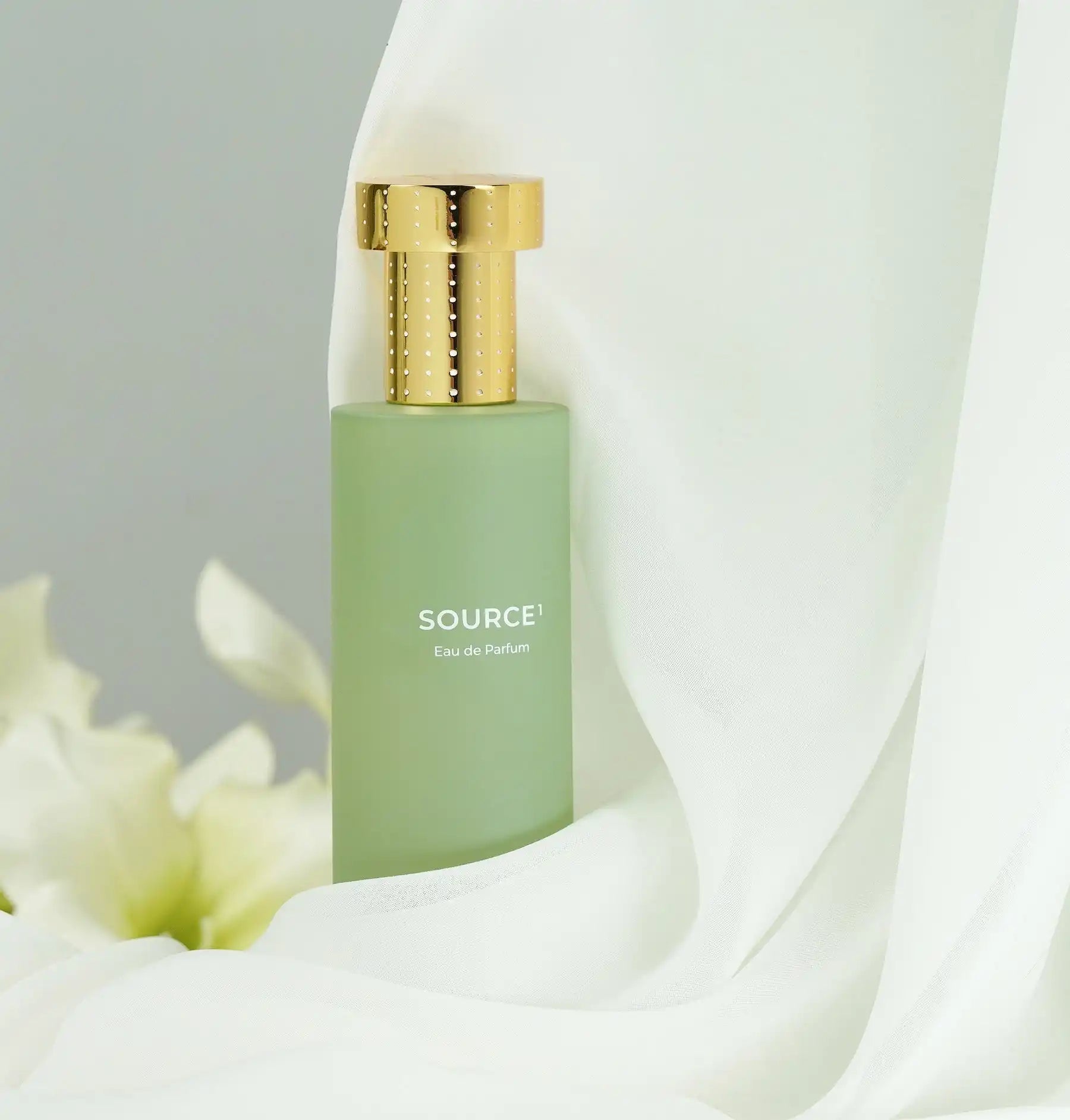 Frosted green glass perfume bottle with a gold cap.